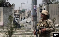 An Afghan security personnel stands guard at the site where a Taliban car bomb detonated at the entrance of a police station in Kabul on August 7, 2019.