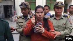 សមត្ថកិច្ច​បណ្តើរ​អ្នកស្រី ទេព វន្នី សកម្មជន​ដី​ធ្លី​ពី​តំបន់​បឹង​កក់​ដែល​កំពុង​ជាប់​ឃុំ​ពី​បទ​ហិង្សា​ដោយ​ចេតនា​មាន​ស្ថាន​ទម្ងន់​ទោស ក្រោយ​បញ្ចប់​សវនាការ​ នៅ​រាជធានី​ភ្នំពេញ កាលពី​ថ្ងៃទី​១៧ ខែ​វិច្ឆិកា ឆ្នាំ​២០១៦។ (កាន់ វិច្ឆិកា/VOA)