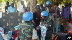 Des soldats de l'ONU portent un bébé Sud-soudanais dans un camp des déplacés à Juba, au Soudan du Sud, 14 juillet 2016. 