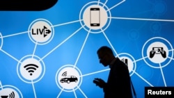 Foto ilustrasi yang menunjukkan seorang pria berdiri di depan stan yang menampikan sejumlah perangkat yang terkoneksi ke Wi-Fi dan jaringan Internet-of-Things. (Foto: Reuters/Paul Hanna)