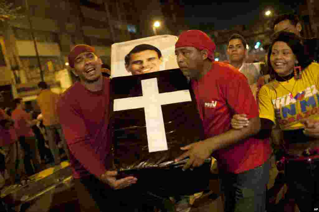 Supporters of Venezuela's President Hugo Chavez perform a mock funeral for opposition candidate Henrique Capriles as they celebrate in downtown Caracas.