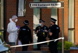 Police officers talk to a forensic technician at the scene outside the Belfairs Methodist Church, where British lawmaker David Amess died after being stabbed at a meeting with constituents, in Leigh-on-Sea, Essex, England, Oct. 15, 2021.