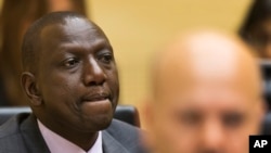 Kenya's Deputy President William Ruto, left, accompanied by his defense counsel, right, awaits the start of his trial on Sept. 10, 2013.