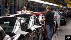 FILE - In this June 15, 2010, file photo, workers at General Motors' plant in Lordstown, Ohio put the final touches on new vehicles.