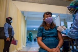 Seorang ibu hamil menerima vaksin Sinovac di Surabaya, 19 Agustus 2021, saat program percepatan vaksinasi. (Foto: AFP/Juni Kriswanto)