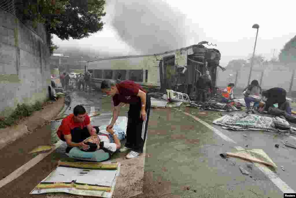 Victims receive help after a train crashed near Santiago de Compostela, northwestern Spain, July 24, 2013. 