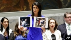 Nikki Haley, United States' Ambassador United Nations, shows pictures of Syrian victims of chemical attacks as she addresses a meeting of the Security Council on Syria at U.N. headquarters, Wednesday, April 5, 2017. (AP Photo/Bebeto Matthews)