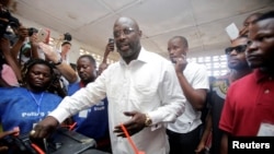 George Weah, former soccer player and presidential candidate of Congress for Democratic Change (CDC), votes at a polling station in Monrovia, Liberia