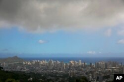 FILE - Clouds hang over Honolulu as Hurricane Iselle approaches. On Wednesday,NOAA's Central Pacific Hurricane Center announces the hurricane season outlook for 2018.