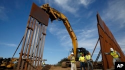 Construction crews install new border wall sections, Jan. 9, 2019, seen from Tijuana, Mexico. U.S. President Donald Trump walked out of his meeting with congressional leaders Wednesday as efforts to end the 19-day partial government shutdown fell into dee