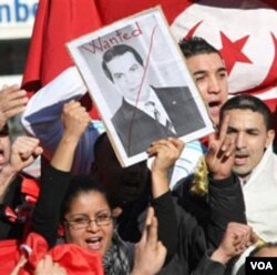 Warga di Tunis melakukan unjuk rasa sambil membawa poster Presiden Ben Ali yang melarikan diri ke Arab Saudi.