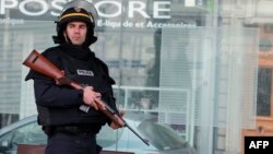 FILE - An armed member of the French riot police (CRS) is seen on patrol at Porte de Vincennes in Paris, Jan. 9, 2015.