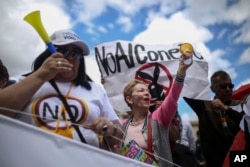 Opponents of peace agreements between rebels of the Revolutionary Armed Forces of Colombia, FARC, with the government gather outside the congress in Bogota, Colombia, Nov. 30, 2016.