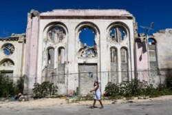 Yon dam pase devan sak rete de Katedral Notre Dame la 12 Janvye 2020, ki se 10e anivese tranbleman te 2010 la.