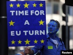 Seorang pengunjuk rasa membawa spanduk menjelang aksi demo anti-Brexit, di pusat kota London, Inggris, 20 Oktober 2018.