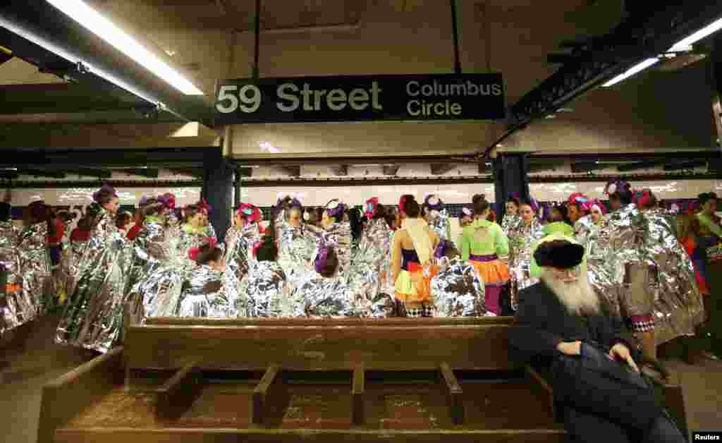 Performers of the 87th Macy&#39;s Thanksgiving Day Parade wait for a subway to take them to the start of the parade in New York.