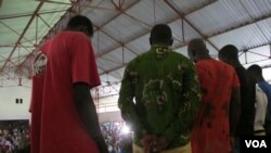 Six young men accused in an attack that injured Red Cross workers in Forecariah, Guinea, apologize at a public meeting before their release Sept. 26, 2014. (Carol Guensburg/VOA)