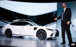 Gill Pratt, CEO of the Toyota Research Institute, unveils Toyota's latest autonomous-driving test vehicle for the Toyota Research Institute, called P4, based on the new-generation Lexus LS500h hybrid luxury sedan, with a roof-mounted assembly with cameras and sensors, and sensors added onto the front fenders, at the Toyota news conference at CES International in Las Vegas, Jan. 7, 2019.