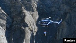 Helikopter penyelamat Perancis mencari puing-puing pesawat Airbus A320 di lokasi jatuhnya, dekat Seyne-les-Alpes, Pegunungan Alpen (27/3). (Reuters/Gonzalo Fuentes)