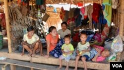 A displaced Kayin family sit in their unit of a shelter at Myaing Gyi Ngu camp, northern Kayin State. (P. Vrieze/VOA)