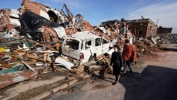 Para warga tampak mensurvei kerusakan yang diakibatkan oleh tornado yang melanda Mayfield, Kentucky, pada 11 Desember 2021. (Foto: AP/Mark Humphrey)