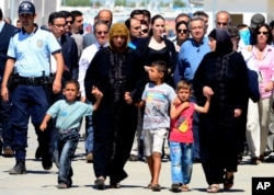 Hollywood star Angelina Jolie, center left, in her role as special envoy for the U. N. refugee agency, and UNHCR chief Antonio Guterres, center right, at the Oncupinar Syrian refugee camp in Kilis, Turkey, September 13, 2012.