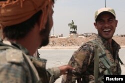 Kurdish fighters from the People's Protection Units (YPG) chat in the Ghwairan neighborhood of Hasaka, Syria, August 22, 2016.