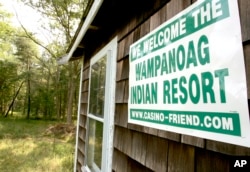 FILE — A poster declaring support for bringing a casino to Middleborough, Mass., appears on the side of a small house on property adjacent to land belonging to the Mashpee Wampanoag tribe.