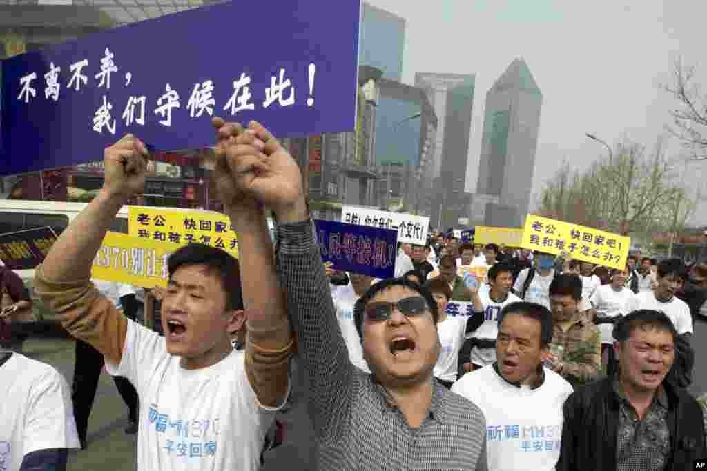 Keluarga penumpang China penerbangan MH370 meneriakkan protes dalam barisan menuju kedutaan Malaysia di Beijing, 25 Maret 2014.