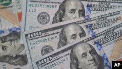 FILE - $100 bills with the likeness of Benjamin Franklin are photographed in Dallas, Texas, Jan. 22, 2020.