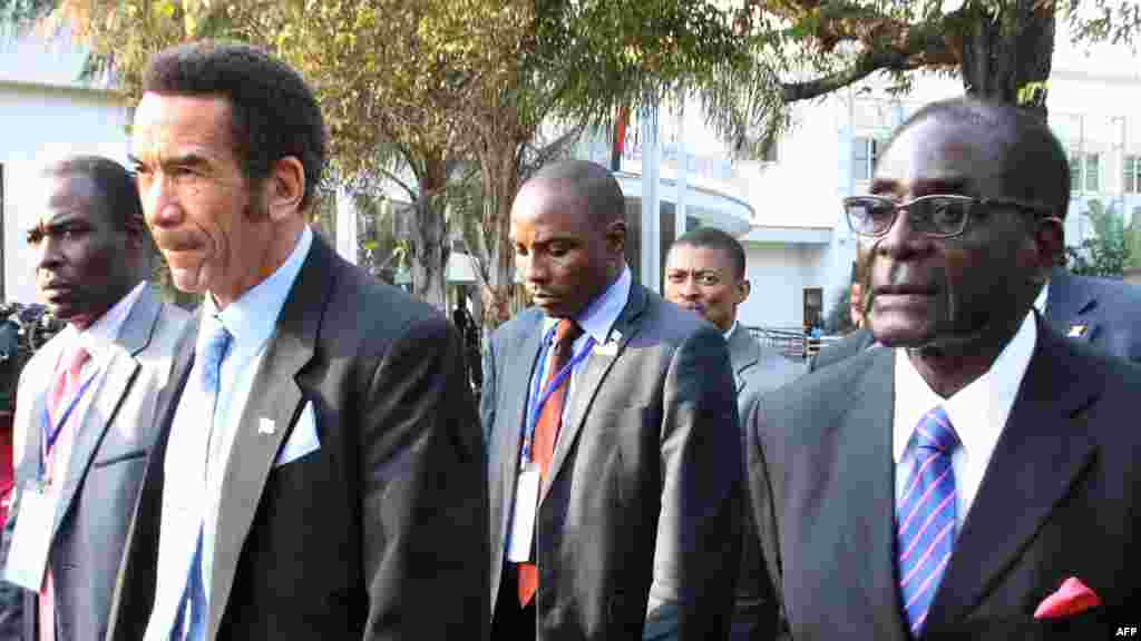 Le président du Botswana Ian Khama (G) marche aux côtés du président du Zimbabwe Robert Mugabe (G) au cours d'une pause déjeuner au sommet de la SADC à Maputo. Mozambique, le 15 Juin, 2013. AFP PHOTO / FERHAT Momade