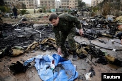 A Russian soldier checks a burned medical tent after rebels launched a mortar shell at a field hospital in west Aleppo, Syria, Dec. 5, 2016.
