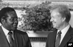 FILE: President Jimmy Carter meets up Zimbabwe Prime Minister Robert Mugabe in the Oval Office in Washington on August 27, 1980. (AP Photo/Barry Thumma)