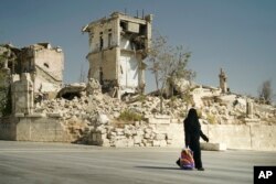 A woman walks in a street in Aleppo, Syria, Sept. 12, 2017.
