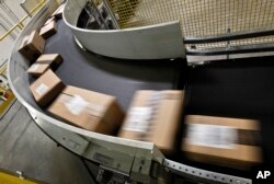 FILE - Packages that are ready to ship move along a conveyor belt at the Amazon.com 1.2 million-square-foot fulfillment center in Phoenix, Arizona, Nov. 26, 2012.
