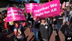 Peserta pawai membawa atribut untuk mengajak bergabung dalam aksi 'Women's March' di pusat kota Losa Ngeles, 20 Januari 2018.