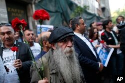 A demonstrator holds carnations during a protest to mark the anniversary of the nationwide summer 2013 Gezi Park protests, in Istanbul, May 31, 2017. Protests began in 2013 as a small environmental sit-in against government plans to raise a central Istanbul park and turned into nationwide demonstrations against the perceived authoritarian style of Turkey's then-prime minister and current president, Recep Tayyip Erdogan.