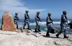 Soldiers of China's People's Liberation Army (PLA) Navy patrol Woody Island in the Paracel archipelago on January 29, 2016.