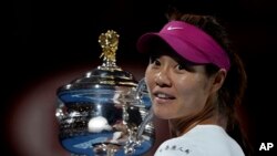 Li Na of China holds the championship trophy at the Australian Open tennis championship.(AP Photo/Andrew Brownbill)