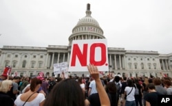 FILE - Activists demonstrate in the plaza of the East Front of the U.S. Capitol to protest the confirmation vote of Supreme Court nominee Brett Kavanaugh on Capitol Hill, Oct. 6, 2018, in Washington.