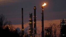 FILE - Stacks and burn-off from the ExxonMobil refinery are seen at dusk in St. Bernard Parish, Louisiana, Feb. 13, 2015.