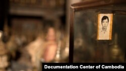 An unidentified picture is seen hanging in from of over 100 cremation urns at public vault at Phnom Penh’s Wat Lanka, Sunday, February 1, 2015. The urns are believed to have been left from Cambodia’s chaotic war period of the 1970s and have yet to be pick