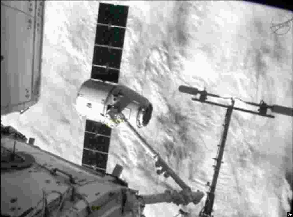 This image from NASA-TV shows the capture of the Dragon capsule by a robot arm on the International Space Station as they passed over the South Atlantic Ocean early October 10, 2012.
