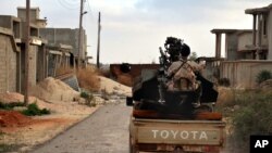 FILE - a man loyal to the Libyan armed forces prepares himself for clashes with Islamic State group militants west of Benghazi, Libya.