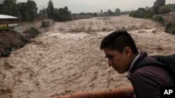 A man looks at the flow of the Huaycoloro river in Lima, Peru, March 16, 2017.