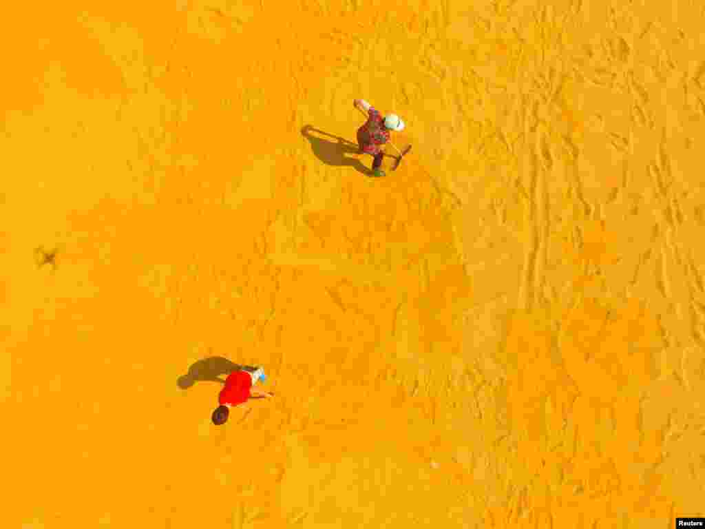People dry crops on a farm in Liaocheng, Shandong Province, China.