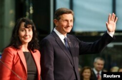 FILE - President Borut Pahor and his wife, Tanja Pecar, react after first results of the second round of the presidential elections in Ljubljana, Slovenia, Nov. 12, 2017.