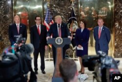 President Donald Trump speaks to the media in the lobby of Trump Tower, Aug. 15, 2017, in New York. With Trump are from left, National Economic Council Director Gary Cohn Treasury Secretary Steven Mnuchin, Transportation Secretary Elaine Chao and OMB Director Mick Mulvaney.