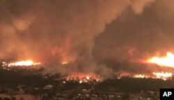 This July 26, 2018, image from video released by Cal Fire shows a fire tornado over Lake Keswick Estates near Redding, Calif. In the history of California wildfires there has never been anything like it.