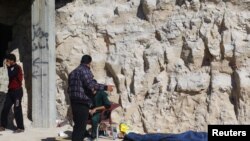 Warga berdiri di dekat mayat korban serangan yang diduga menggunakan gas beracun di kawasan Khan Sheikhoun, Idlib, Suriah, yang dikuasai oleh pemberontak, 4 April 2017.